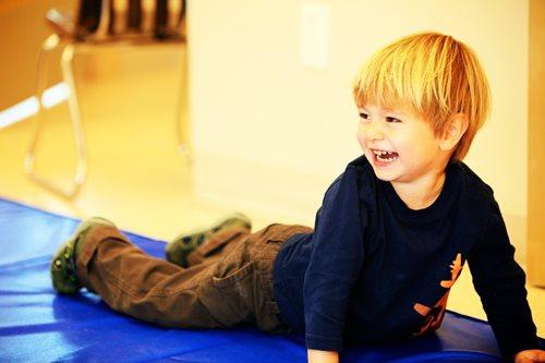 Young boy smiling while playing on the floor